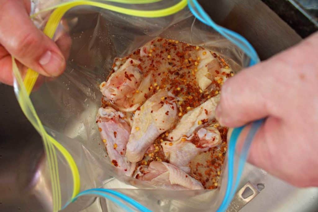 raw chicken wings in a zip-top bag of brine solution