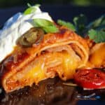 Leftover brisket? Make this recipe for smoked beef brisket enchiladas! Smoky brisket wrapped in tortillas smothered in enchilada sauce and gooey cheese.