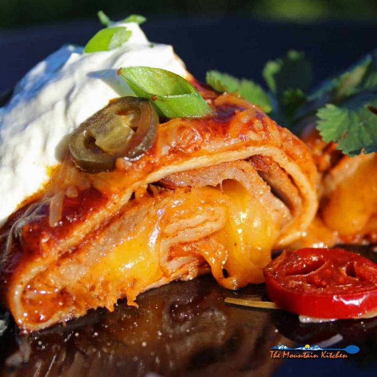 Leftover brisket? Make this recipe for smoked beef brisket enchiladas! Smoky brisket wrapped in tortillas smothered in enchilada sauce and gooey cheese.