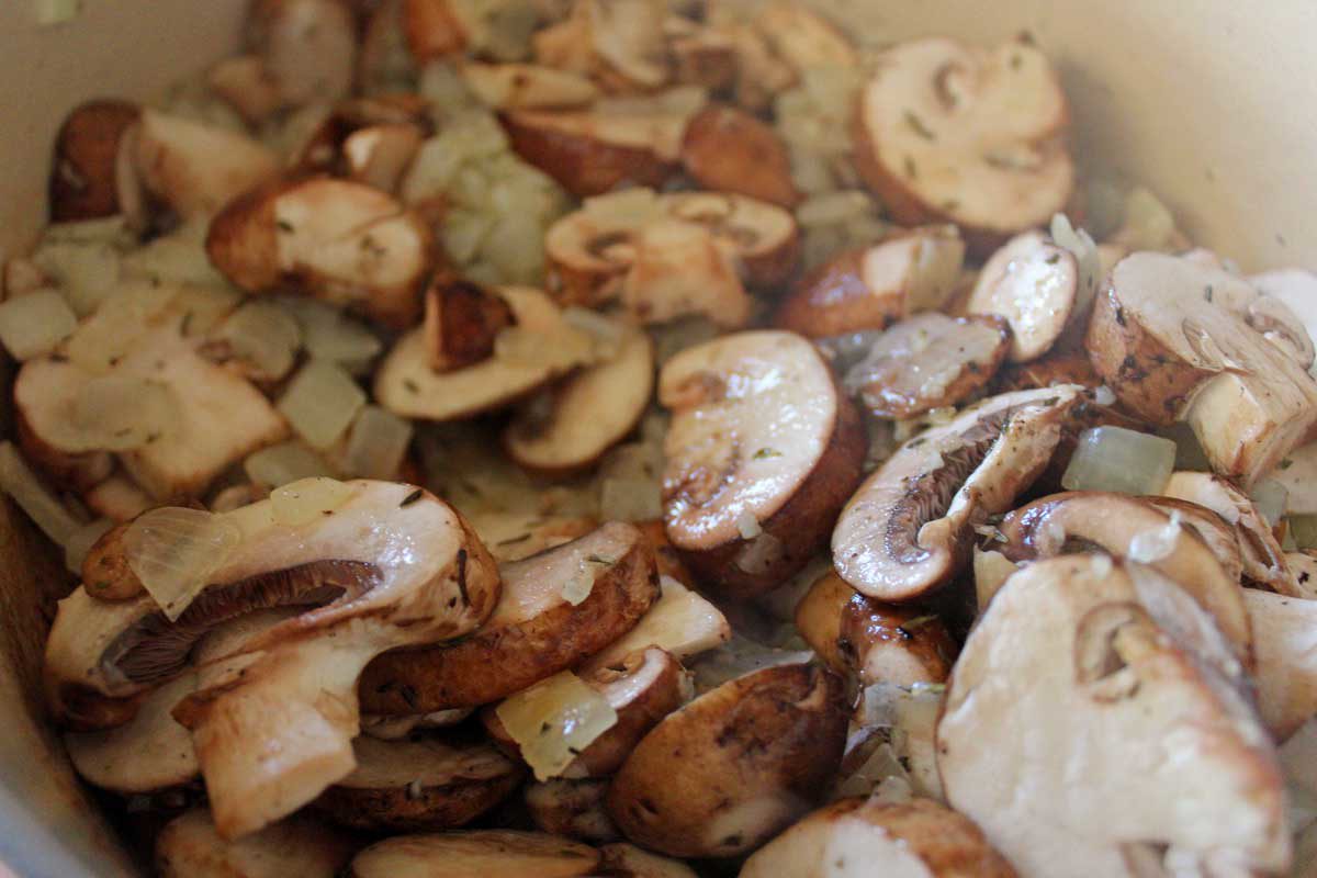 mushrooms and onions cooking in a pot