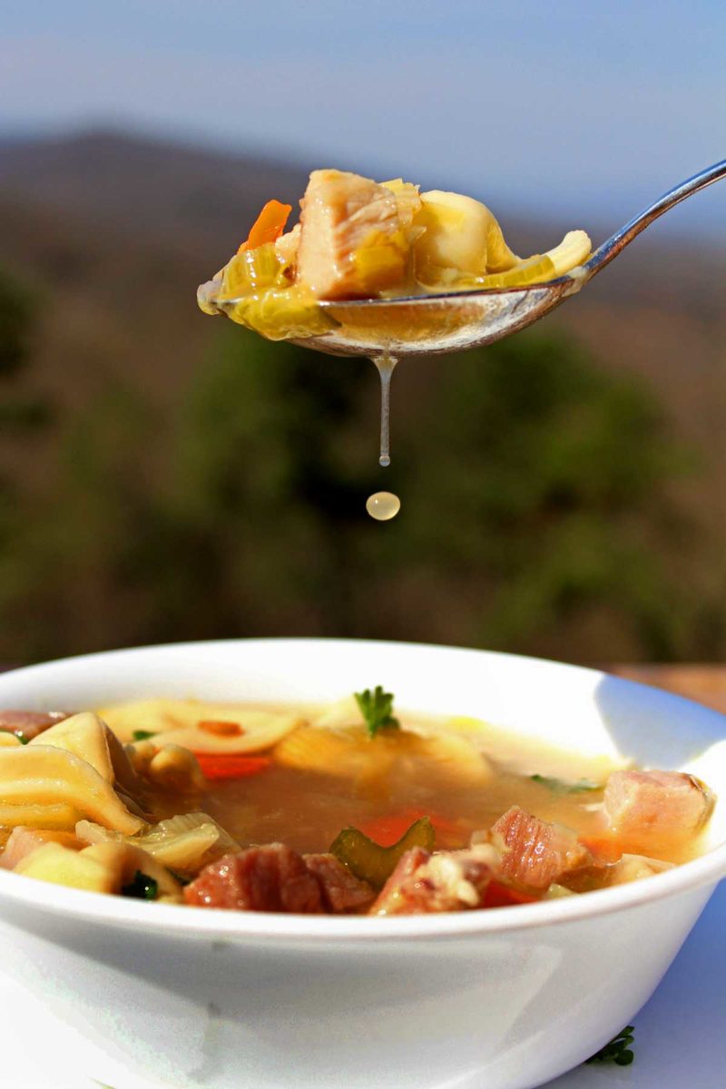 a spoonful of brodo with a droplet falling out