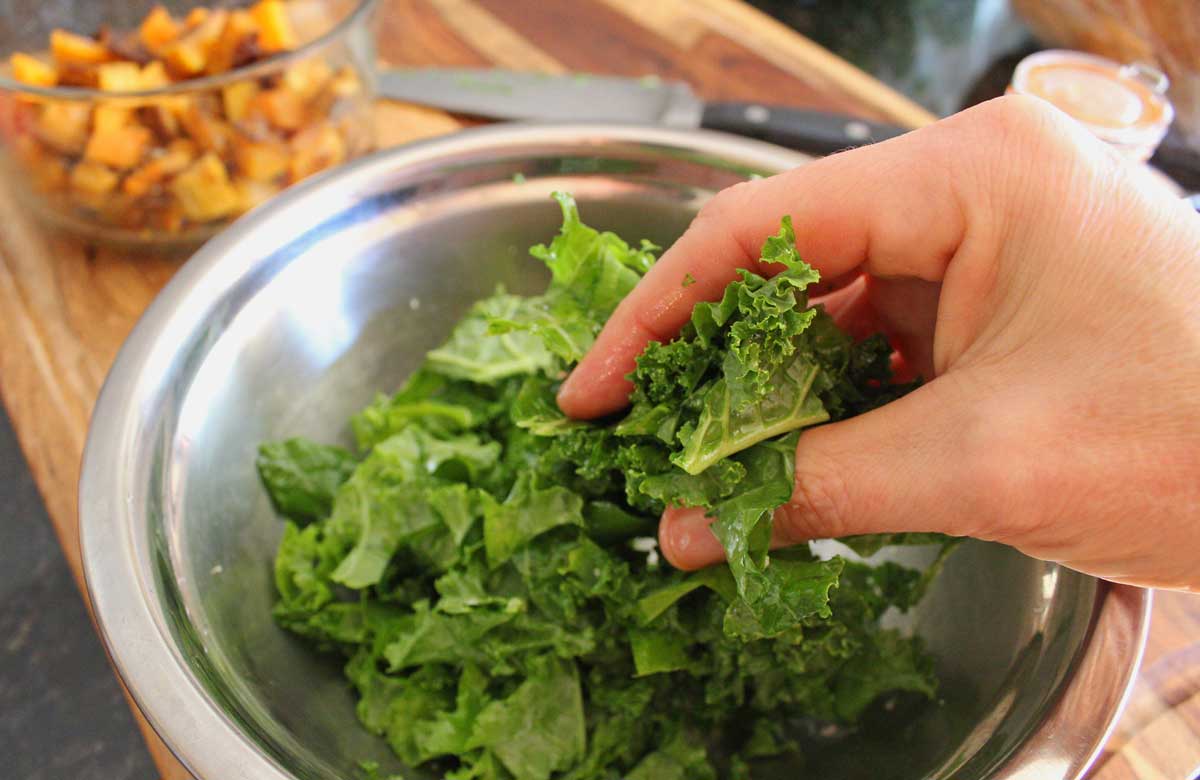 massaging kale with oil inside a bowl
