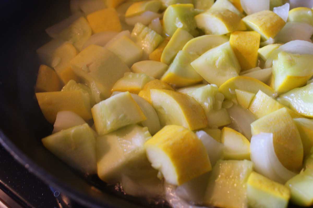 squash and onions cooking in a pan