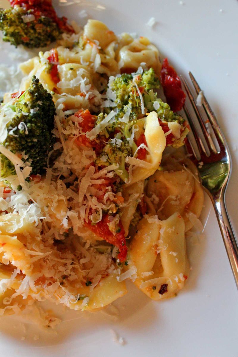 a portion of the pasta plated with parmesan cheese and a fork