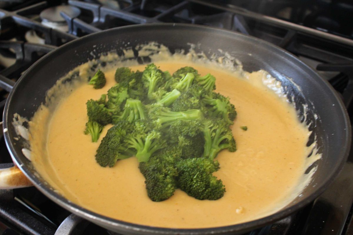 broccoli in a pan of cheese sauce