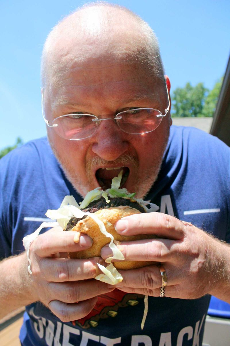 David going in for a bite of the big twin double cheeseburger