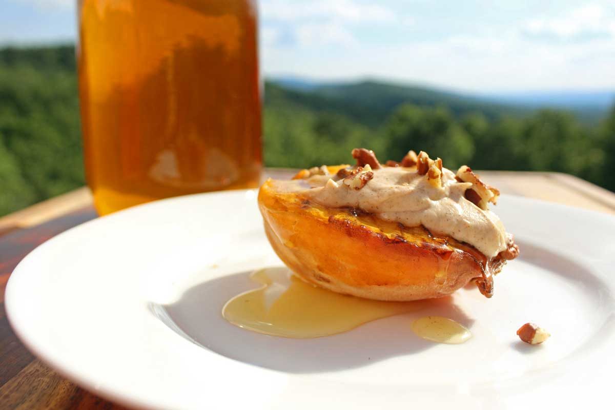 grilled peach topped with cinnamon ricotta creme pecans and honey