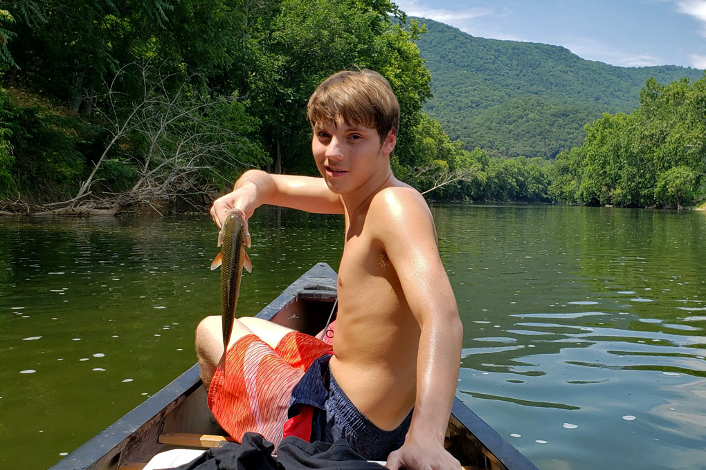seth in canoe with fish