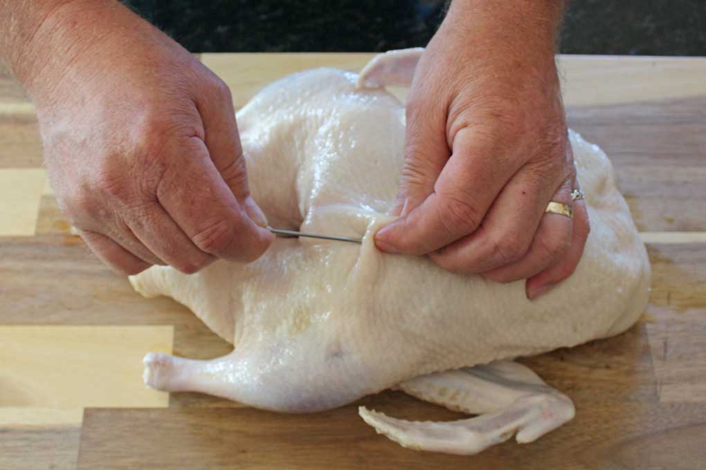 piercing the duck breast with skewer