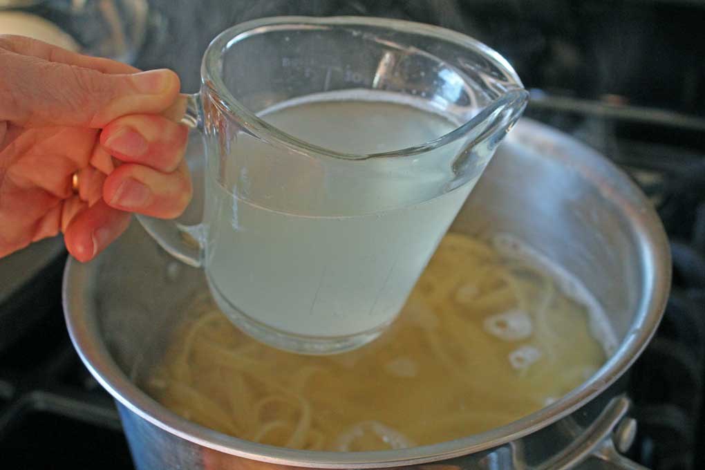 reserving pasta water from pot