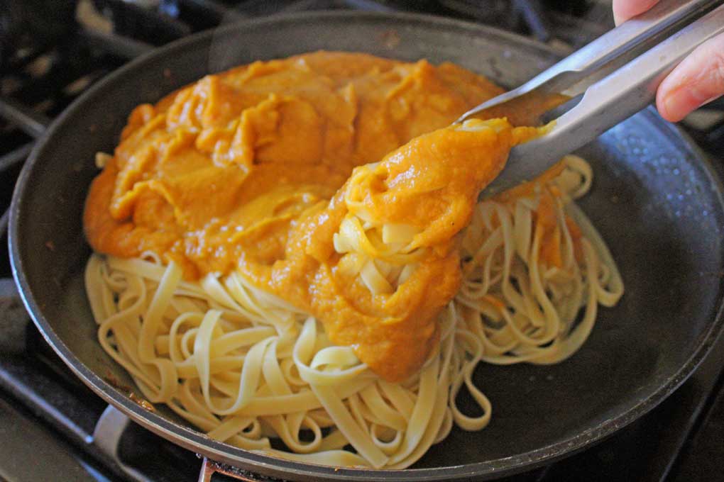tossing pasta with butternut squash sauce
