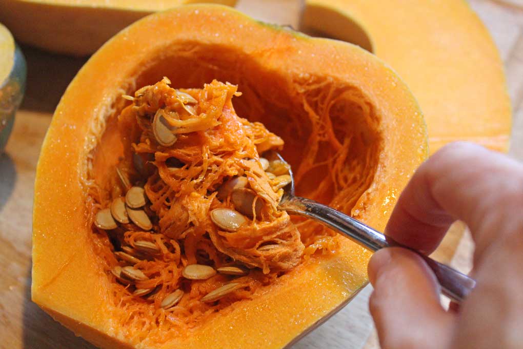 scooping out seeds and pulp with spoon
