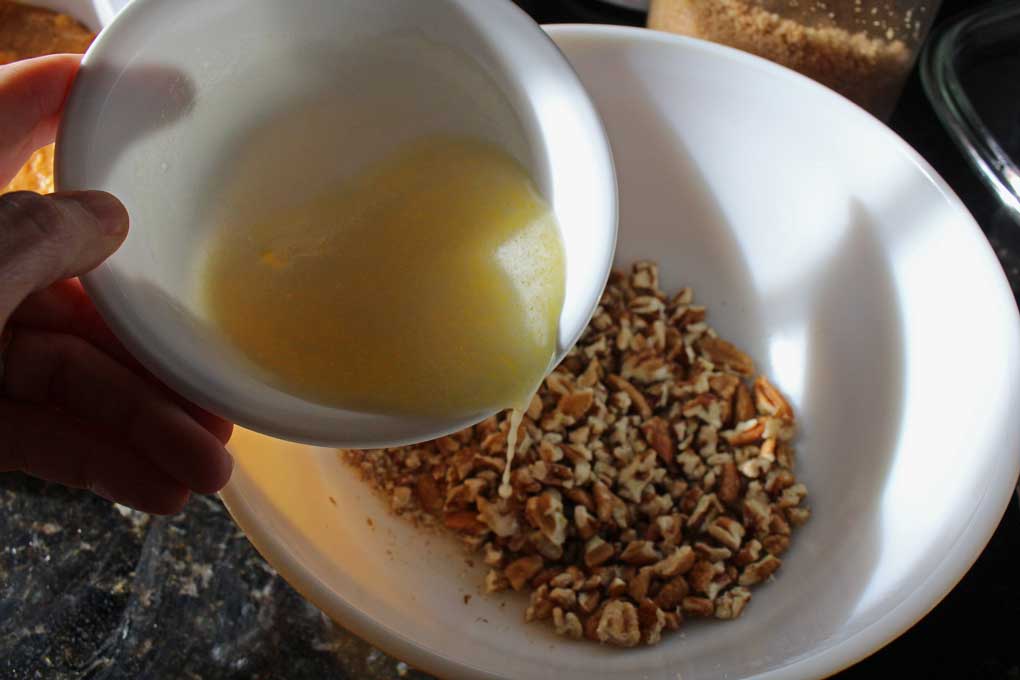 pouring butter into pecan mixture