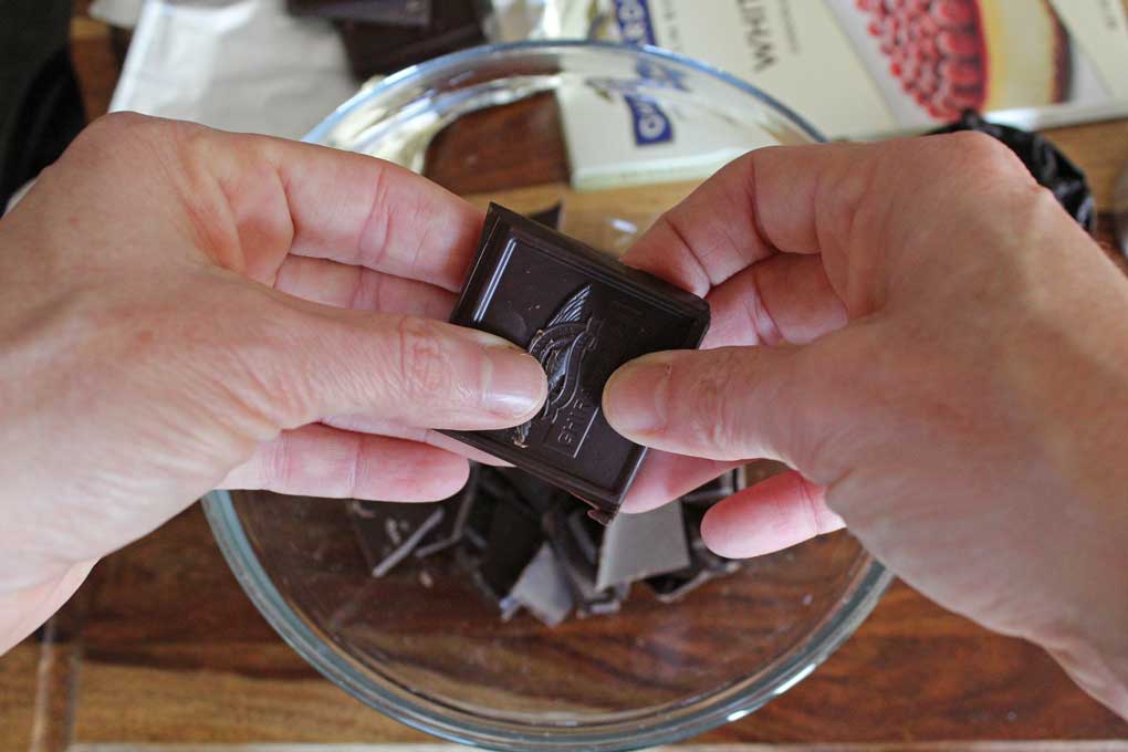 breaking chocolate into bowl