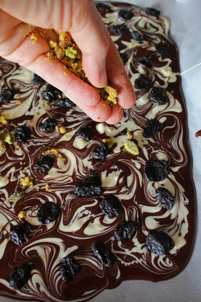 sprinkling pistachios onto chocolate