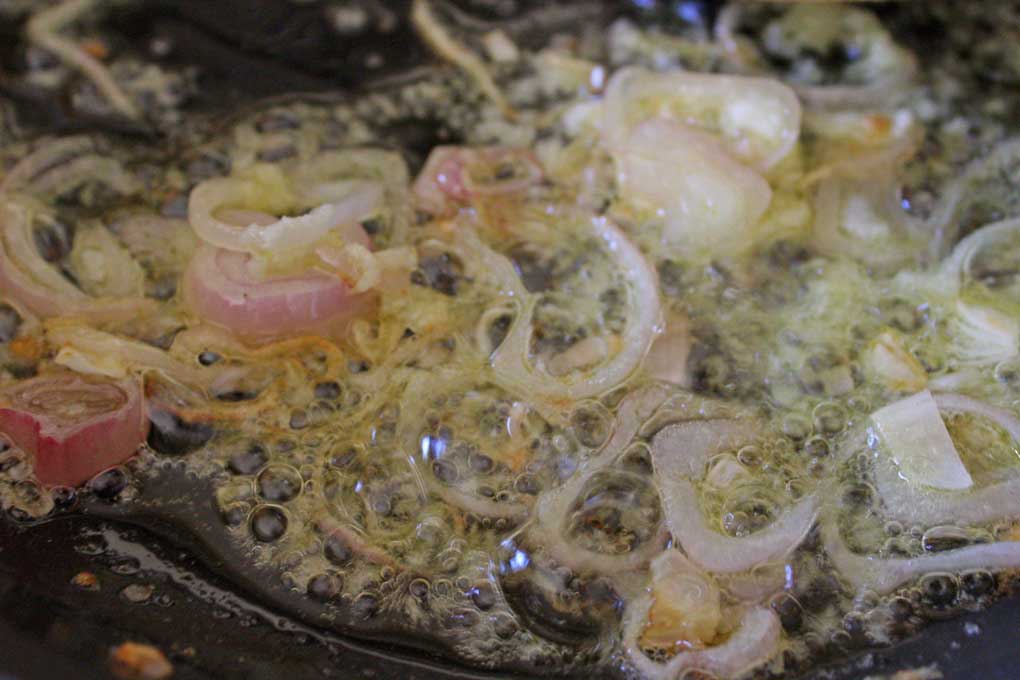 shallots cooking in skillet with oil and butter