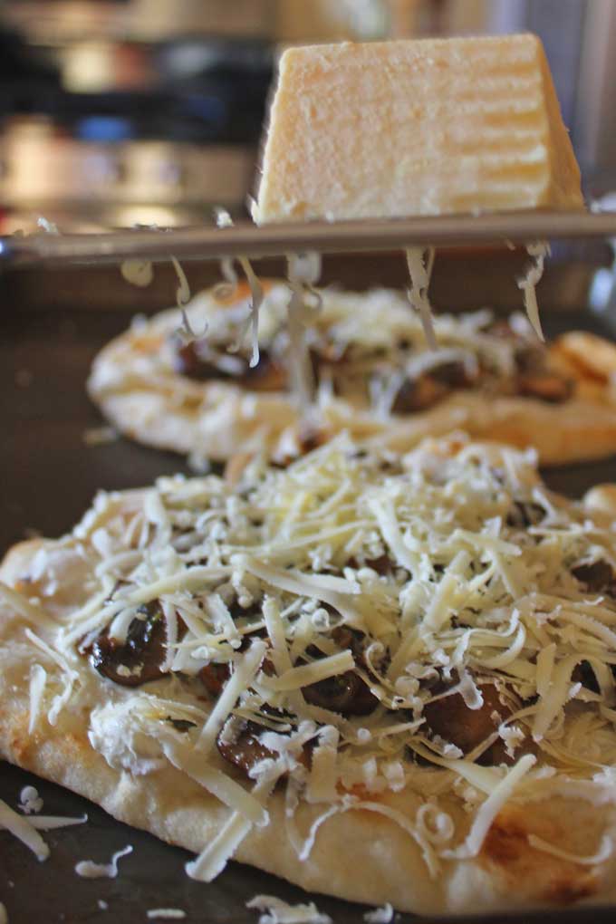 adding shredded cheese on top of mushrooms