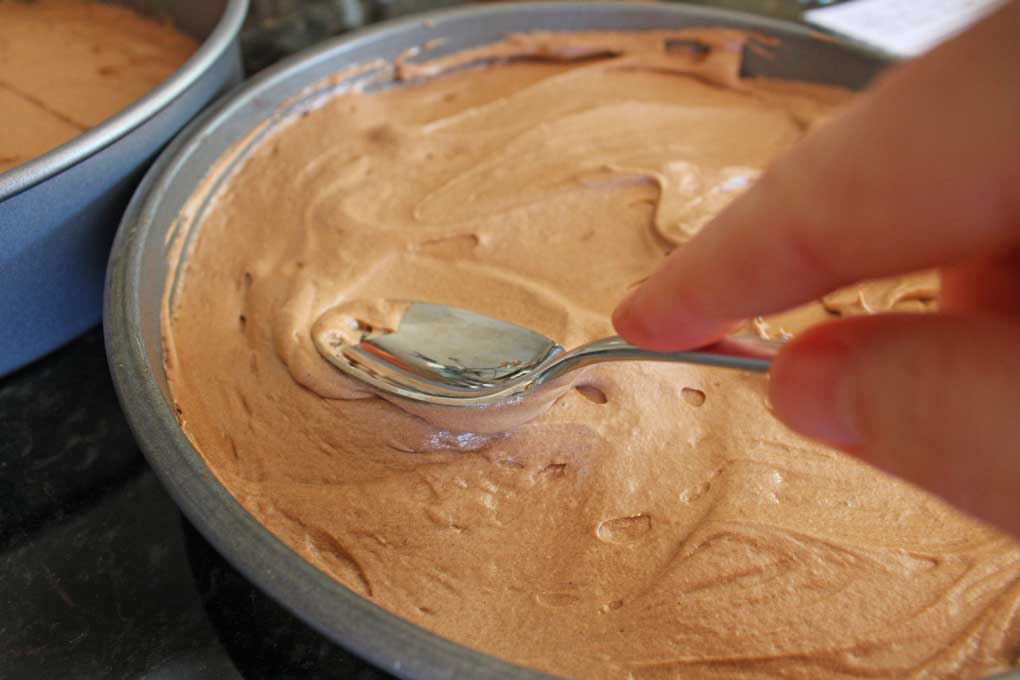 smoothing cake batter out with the back of spoon
