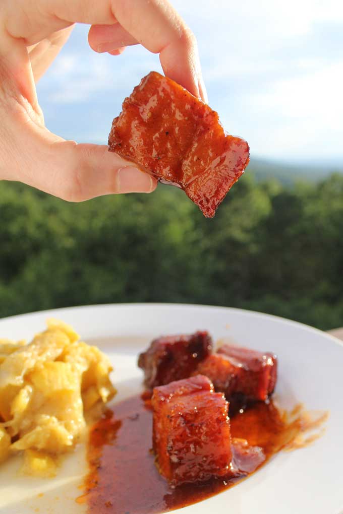 bite size piece of saucy smoked pork belly with mountain view
