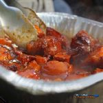 tossing smoked pork belly burnt ends in sauce on grill