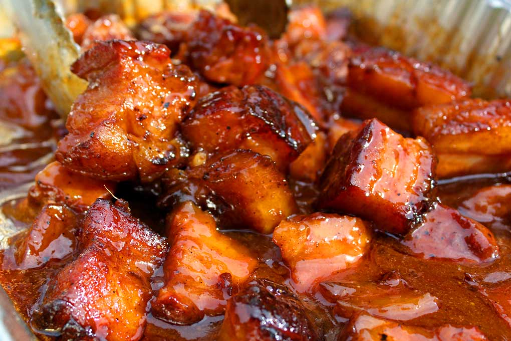 pork belly burnt ends covered in barbecue sauce