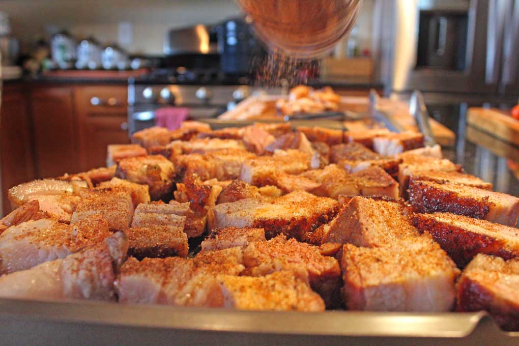 sprinkling pork belly with rub