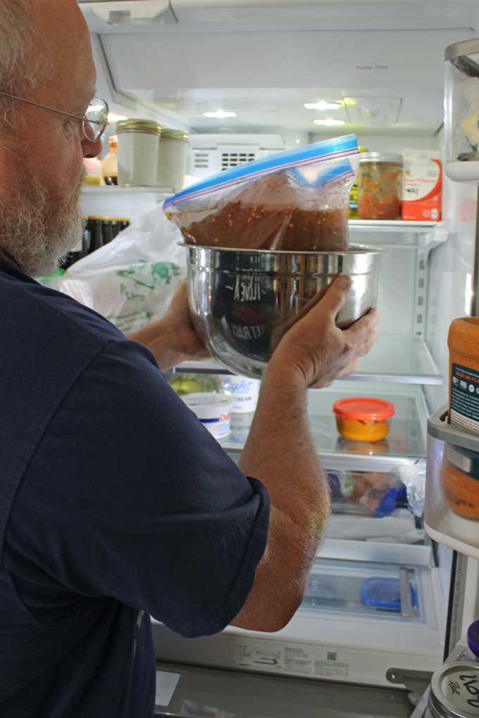 David placing pork in fridge