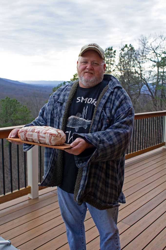 David holding meatloaf on cedar plank