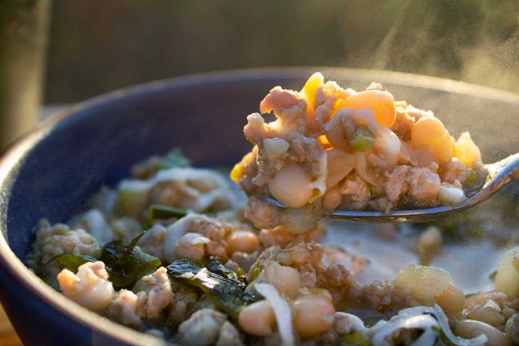 steaming spoonful of white bean and pork chili