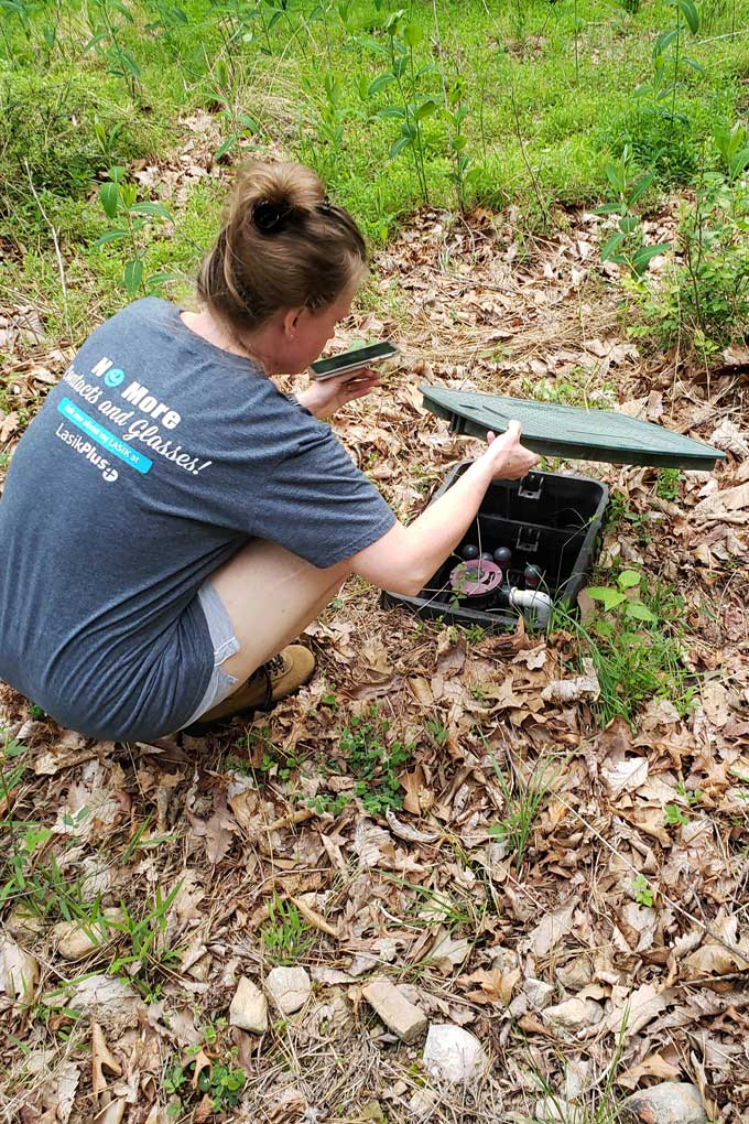 Debbie putting drain field cover back on