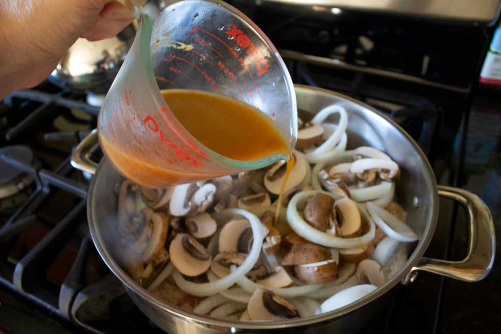 Pouring sauce into pan to make pork chop stroganoff