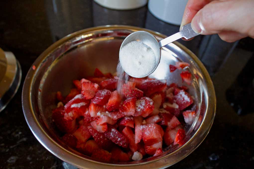 adding sugar to strawberries