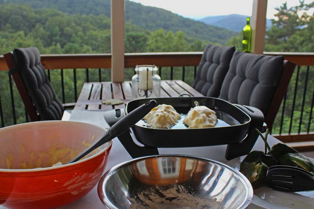 frying pan outdoors with frying authentic chiles rellenos