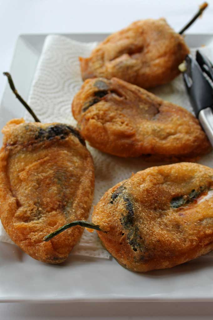 draining authentic chile rellenos on platter