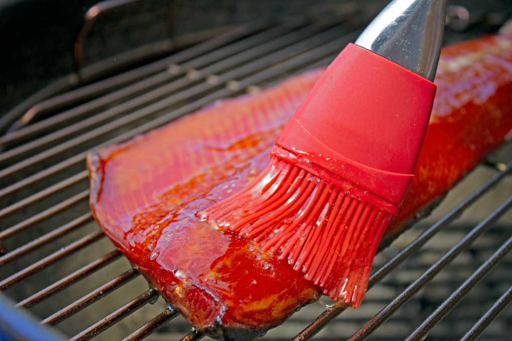 brushing honey onto honey smoked salmon