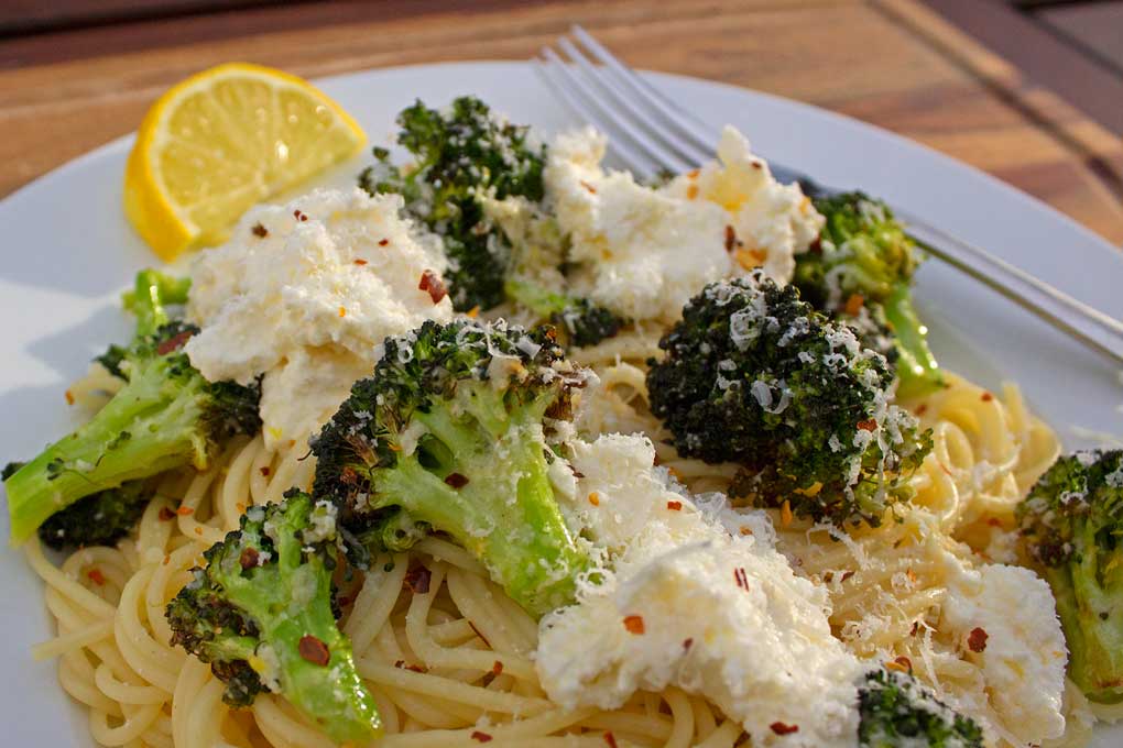 Air fryer broccoli with ricotta and pasta on a plate with fork