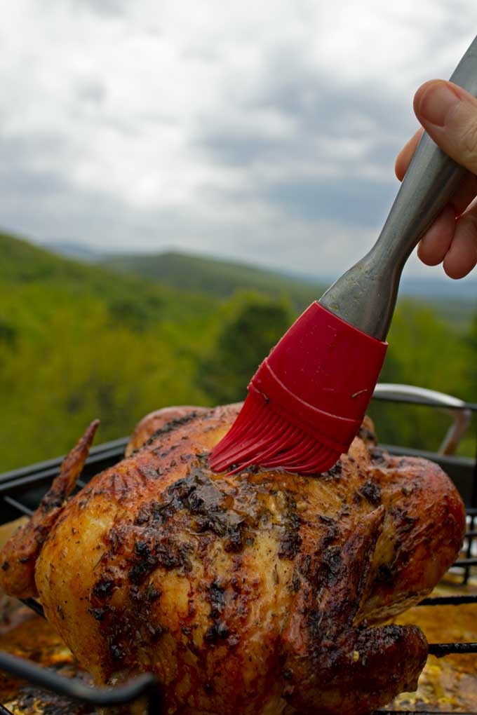 brush basting garlic herb-butter roasted chicken