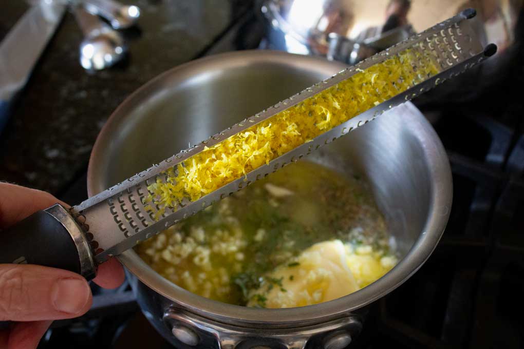 lemon zest on microplane over pot on stove