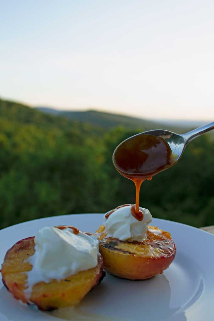 drizzling caramel sauce on top of yogurt and peaches and plums
