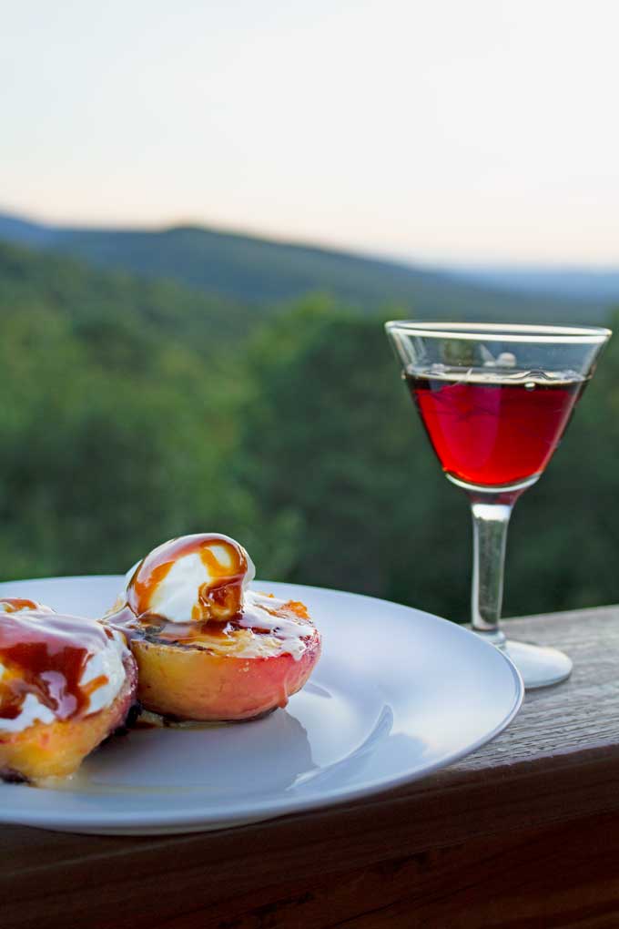 a glass of port beside plate of stone fruit