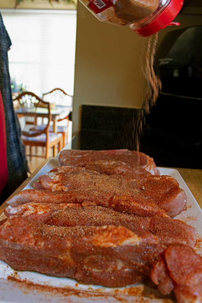 sprinkling rub onto pork ribs