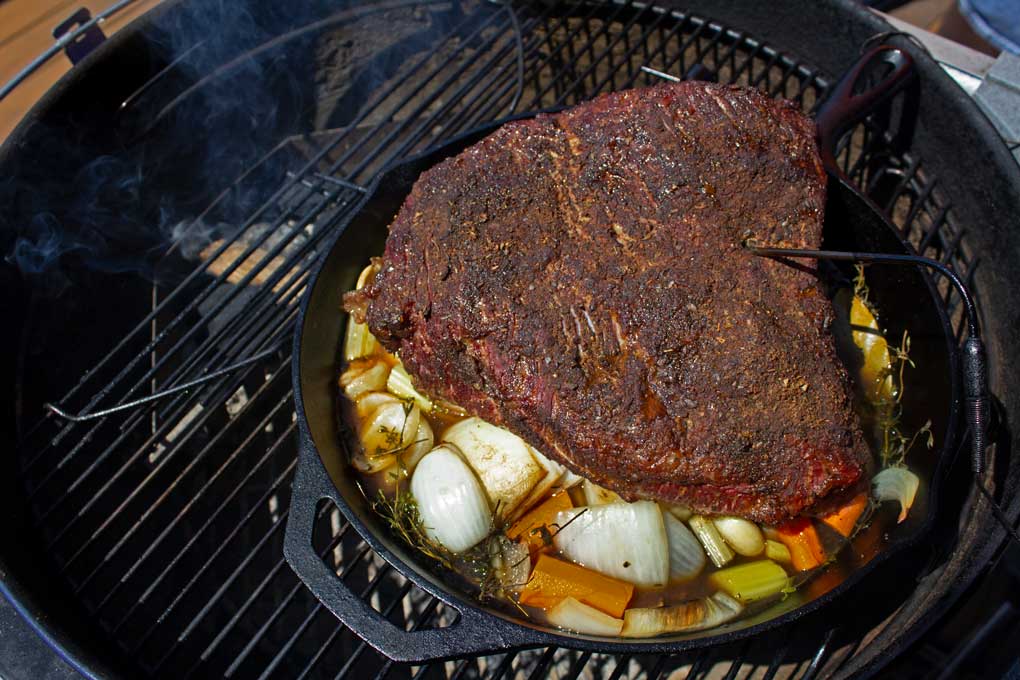 smoked brisket in cast iron pan with vegetables