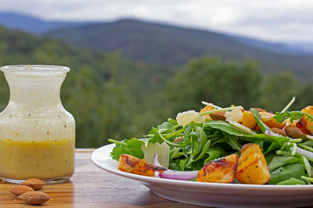 butternut squash arugula salad with mountain view and bottle of dressing