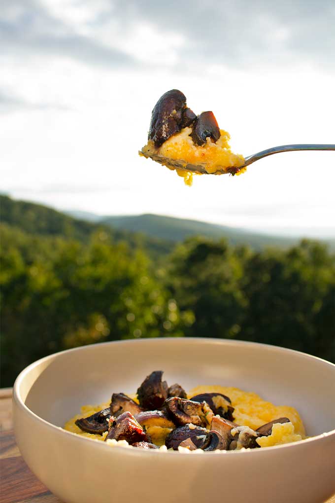 spoonful of polenta and mushrooms with mountain view