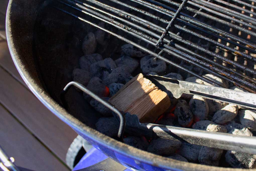 placing wood chunk in charcoal basket