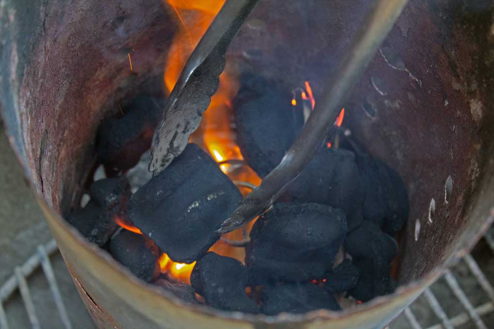 lit charcoal inside charcoal chimney
