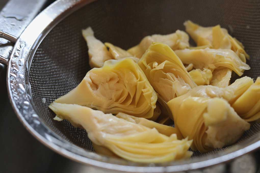 artichokes draining in sieve