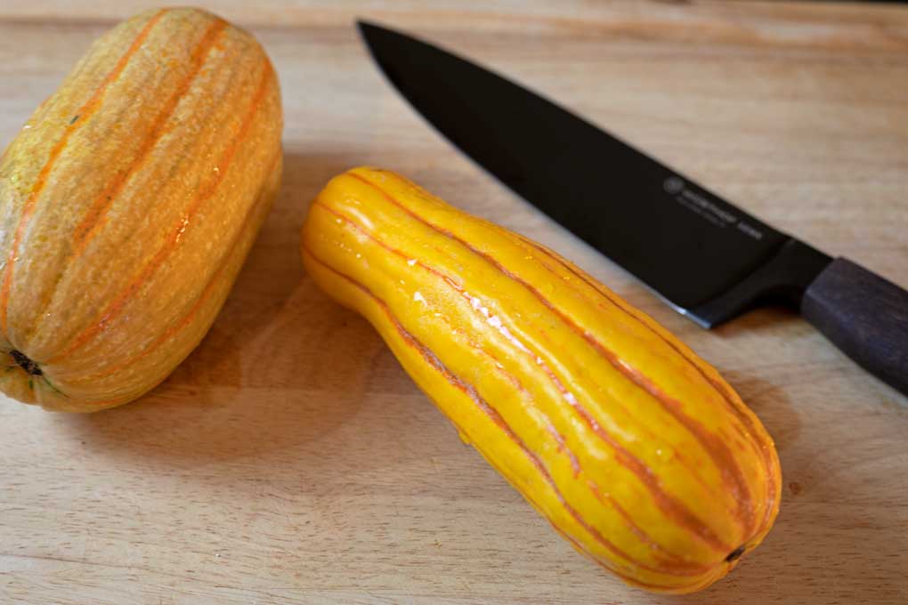 delicata squash on cutting board with knife