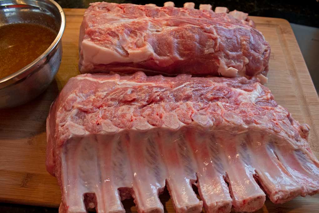 racks of pork with bowl of brine