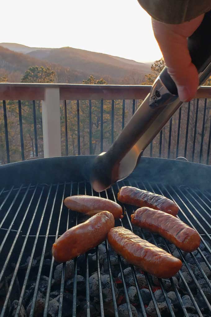 sausages on grill with mountain view